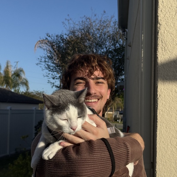 Donovan Stonebreaker holding a gray and white cat
